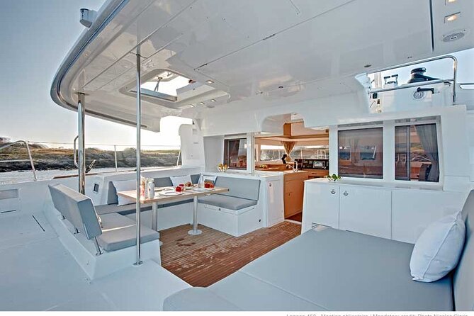 Deluxe Santorini Sailing with BBQ and Drinks Shared Tour - Passing the Lighthouse and Indian Head Mountain: the sail-by moment