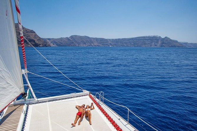 Sailing Catamaran Cruise in Santorini with BBQ, Drinks and Transfer - Boat comfort: top-deck time, restrooms, and choppy-water prep