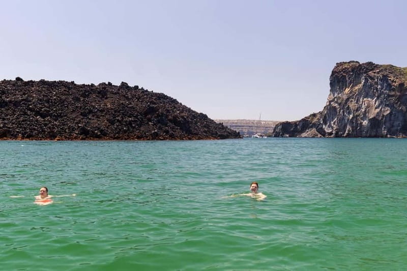 Santorini: Catamaran Cruise with Fresh Meal & Open Bar - Akrotiri Lighthouse and the caldera from sea level