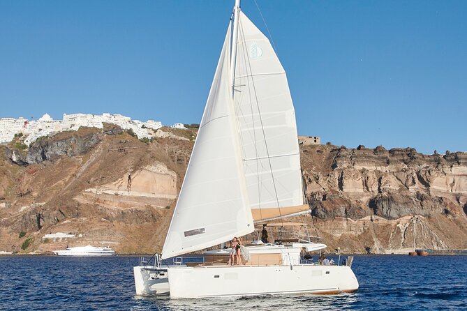 Santorini Gold Catamaran Cruise with BBQ, Drinks and Hotel Pickup - Drinks, Music, and On-Board Comfort (Air-Conditioning and Restrooms)