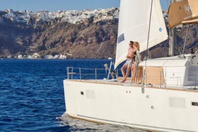 Santorini Gold Catamaran Cruise with Snorkel, BBQ & Open Bar - White Beach viewpoints and the Venetian lighthouse from the sea