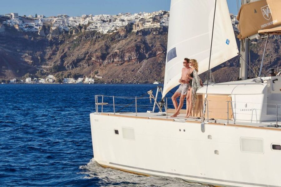 Santorini Gold Catamaran Cruise with Snorkel, BBQ & Open Bar - White Beach viewpoints and the Venetian lighthouse from the sea