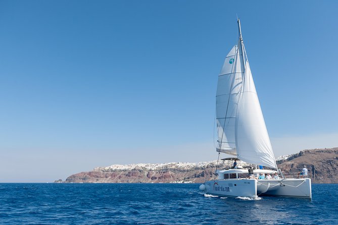 Santorini Small-Group Catamaran Sailing Trip(BBQ,drinks, transfer) - Watching the lighthouse from the sea: a quieter kind of wow